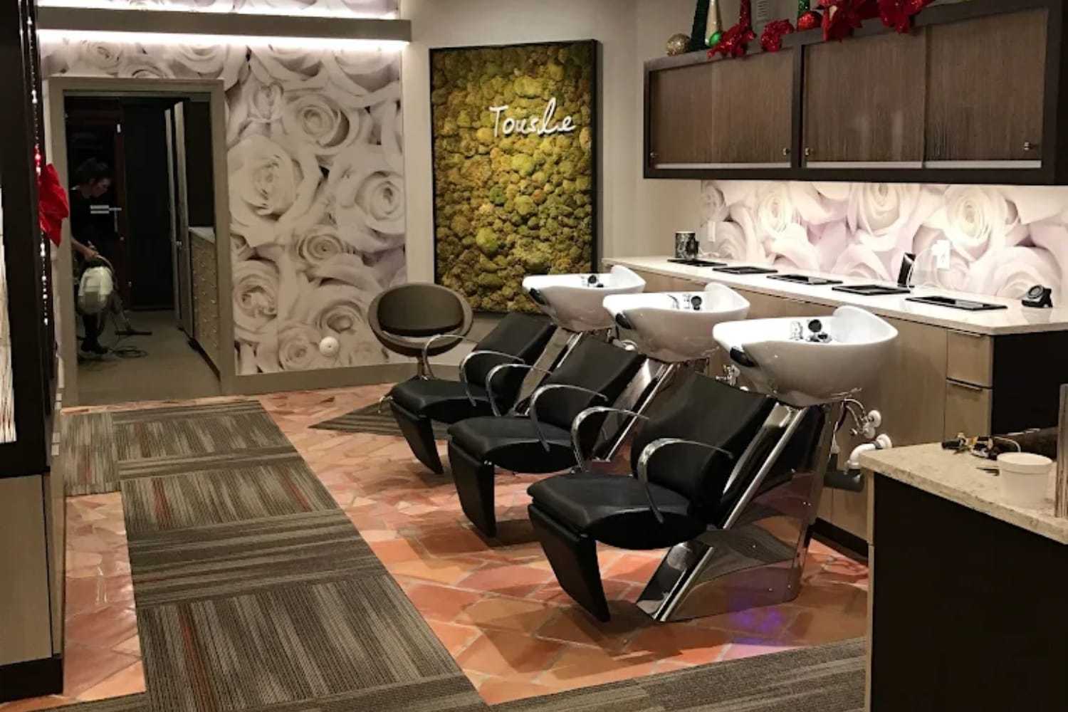 Elegant salon with modern hair washing stations and floral wall decor.
